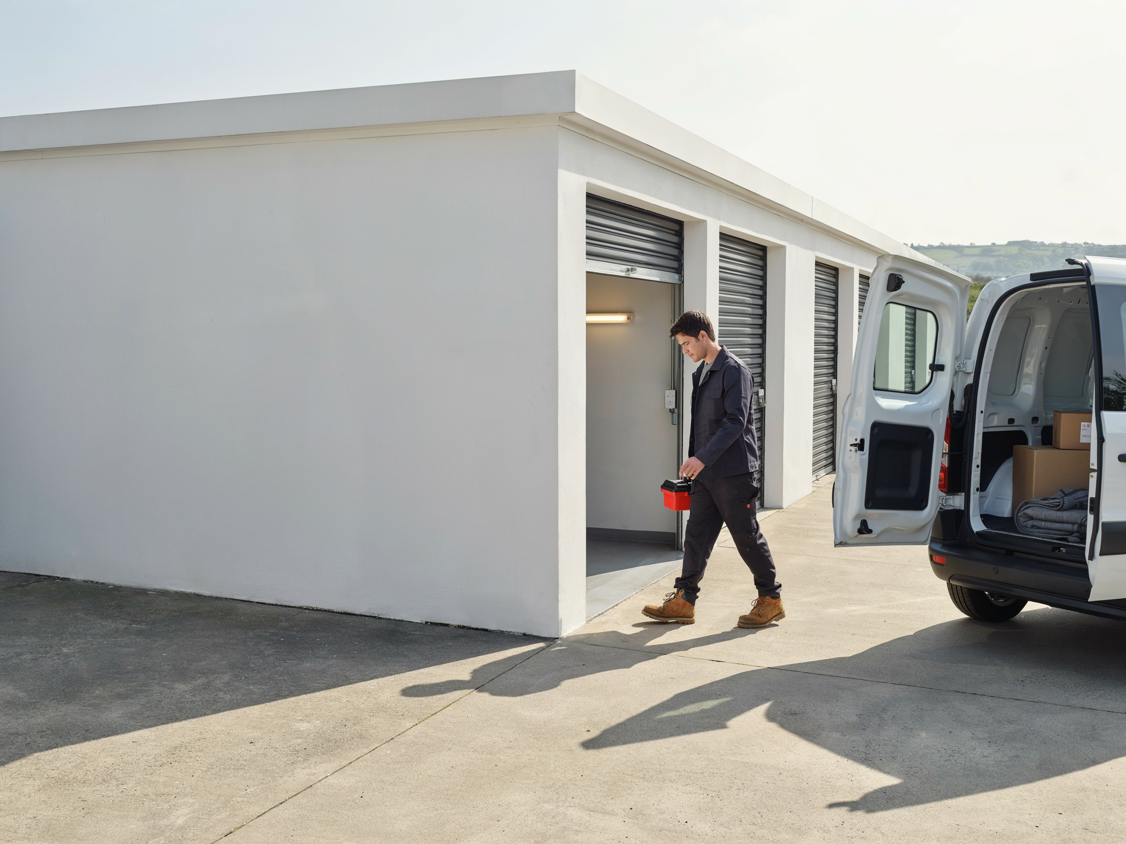Tradesperson working from an open unit, van alongside